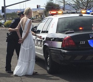 This photo provided by the Marana Police Department, in Arizona, shows 32-year-old Amber Young during her arrest on suspicion of impaired driving, Monday, March 12, 2018, in southern Arizona. Police say Young became involved in a car crash in Marana as she was driving to her wedding. One person suffered minor injuries in the three-vehicle crash. (Marana Police Department via AP)