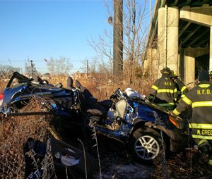 In this photo provided by the Hackensack Fire Department, firefighters work the scene of an accident near an overpass along Route 80 in Hackensack, N.J., Friday, Feb. 13, 2015. An SUV driver swerving to avoid striking another vehicle on the highway hit a snowbank along a guardrail and catapulted 60 feet off a bridge. Incredibly, authorities say, the two occupants suffered only minor injuries, and the vehicle landed upright. (AP Photo/Hackensack Fire Department, Justin Derevyanik)