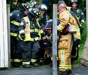 First responders move a driver from a school bus that crashed near Kirkwood, Mo. (Robert Cohen/St. Louis Post-Dispatch via AP)