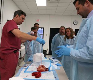Dr. James Vosswinkel, left, the chief of trauma, emergency surgery, and surgical critical care, at Stony Brook University Hospital, demonstrates how to pack a gunshot wound on a fake body part during a first aid training session at Stony Brook University in New York, Tuesday, Nov. 29, 2016. (AP Photo/Michael Balsamo)