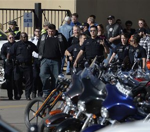 Denver Police escort a man in handcuffs away from the National Western Complex, Saturday, Jan. 30, 2016. (AP Image)