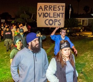In this Feb. 22, 2017 file photo, protesters march towards a police officer's home, who pulled out a gun and fired a warning shot during an off-duty scuffle with a teenager, in Anaheim, Calif. (Joshua Sudock /The Orange County Register via AP, File)