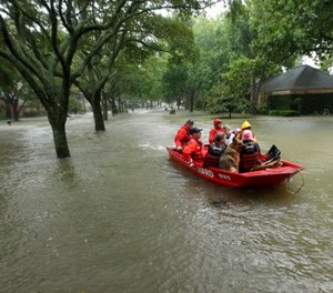 A Coast Guard rescue team evacuates people from a neighborhood inundated by floodwaters from Tropical Storm Harvey on Monday, Aug. 28, 2017, in Houston, Texas. (AP Photo/Charlie Riedel)