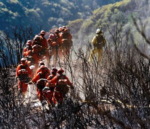 CAL FIRE Inmate Firefighting Hand Crew members hike through the charred landscape on their way to work east of Gibraltar Road above Montecito, Calif. (Mike Eliason/Santa Barbara County Fire Department via AP)