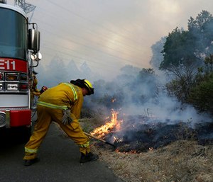 Santa Rosa firefighters work on a fire on the side of a road near the Oakmont area in Santa Rosa, Calif.
