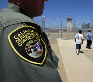 In this June 20, 2018 file photo , inmates pass a correctional officer as they leave an exercise yard at the California Medical Facility in Vacaville, Calif. (AP Photo/Rich Pedroncelli, file)