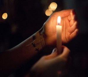 Randi Landry, of Lafayette, holds a candle during a vigil to honor the victims of Thursday night's shooting at The Grand 16 theater Friday, July 24, 2015, in Lafayette, La. (AP Image)