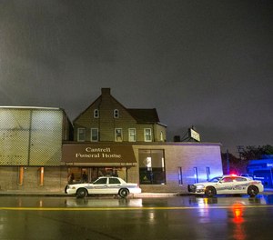 Detroit Police vehicles are parked outside of the Cantrell Funeral Home in Detroit on Friday, Oct. 12, 2018. Police said an anonymously written letter led inspectors to find the decomposed remains of 11 infants hidden in a ceiling compartment of the shuttered funeral home.