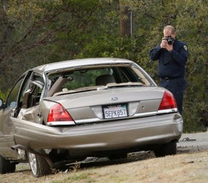 A California Highway patrol officer photographs a vehicle involved in a deadly shooting rampage at the Rancho Tehama Reserve, near Corning, Calif., Tuesday, Nov. 14, 2017.