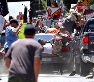 In this Saturday, Aug. 12, 2017 file photo, people fly into the air as a vehicle drives into a group of protesters demonstrating against a white nationalist rally in Charlottesville, Va. (Ryan M. Kelly/The Daily Progress via AP, File)