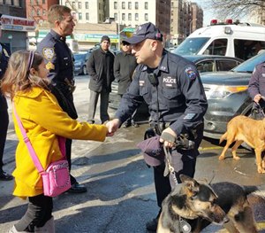 Savannah Solis, left, is greeted by a New York City police officer while visiting a police precinct in the Bronx, Tuesday, Feb. 24, 2015.