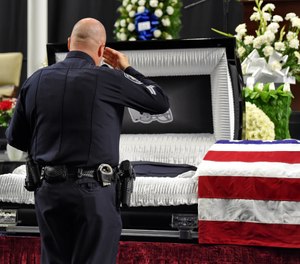 Mourners and police officers from around the country attend a memorial service before the funeral for fallen Florence police officer Sgt. Terrence Carraway Monday, Oct. 8, 2018, at the Florence Center in Florence, S.C. Sgt. Carraway was killed in the line of duty Wednesday, Oct. 3, 2018. (AP Photo/Richard Shiro)