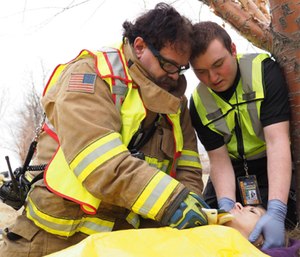 Rick Howe, left, and William Cook place a cervical collar on simulated casualty played by Alaska State Defense Force Cpl. Suzan Palmer at the Alaska State Fairgrounds during exercise Alaska Shield 2016.