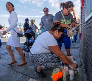 People gather at a makeshift memorial on the corner of Indiana Street and Whittier Blvd. in Boyle Heights, Friday, Nov. 17, 2017.