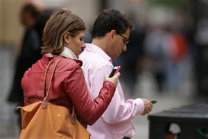 People use cellphones in downtown San Francisco.