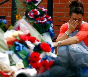 Katrina Ebbers, whose husband is a Lincoln County Sheriff's deputy, cries as she sits near the makeshift memorial for slain Lincoln County Sheriff's Office deputy William Durr at the Lincoln County-Brookhaven Government Complex in Brookhaven, Miss., Tuesday, May 30, 2017. (AP Photo/Rogelio V. Solis)