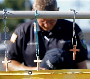 Millville, N.J. police chaplain Robert Ossler prays Monday, July 18, 2016, at a makeshift memorial at the fatal shooting scene in Baton Rouge, La., where several law enforcement officers were killed.