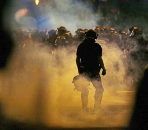 Police fire teargas as protestors converge on downtown following Tuesday's police shooting of Keith Lamont Scott in Charlotte, N.C., Wednesday, Sept. 21, 2016.