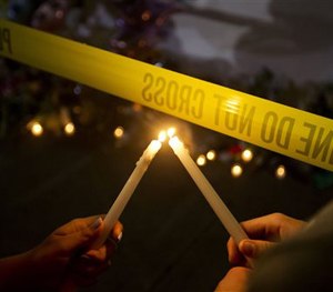 Olina Ortega, left, and Austin Gibbs light candles at a sidewalk memorial in front of Emanuel AME Church.