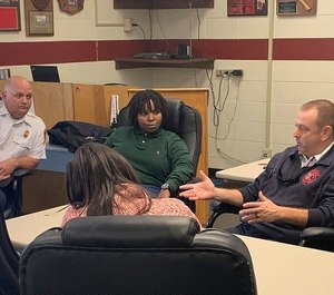 Chattanooga Fire Capt. and EMS Coordinator Skyler Phillips (left), University of Tennessee Social Work Clinical Instructor April Wilson (center, in green) and Fire Chief Phil Hyman (right) discuss the fire department's outreach program for frequent 911 callers and its results at the Chattanooga Fire and Police Training Center this week.