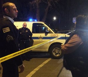 A Chicago police sergeant speaks with a relative of a man who was killed by a police officer in the West Garfield Park neighborhood in Chicago, early Saturday, Dec. 26, 2015.