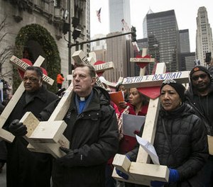 The Rev. Michael Pfleger, third from left, the Rev. Jesse Jackson, second from left, and state Sen. Jacqueline Collins, right, led hundreds in a march down Michigan Avenue, carrying crosses for all those killed by Chicago violence in 2016 and to call for an end to violence in 2017, Saturday, Dec. 31, 2016, in Chicago.