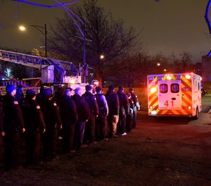 Chicago police officers and firefighters form an honor guard as the body of Chicago Police Officer Samuel Jimenez is brought to the coroner Monday, Nov. 19, 2018, in Chicago. (AP Photo/David Banks)