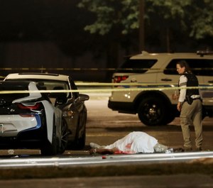 In this Aug. 20, 2017, file photo, a police detective walks past the body of a man fatally shot in the parking lot of an event center in Chicago. (Photo/AP)