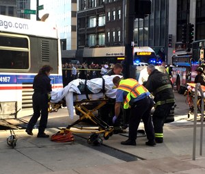A victim receives help after a bus crash at the corner of Lake Street and Michigan Avenue in Chicago on Tuesday, June 2, 2015. (Steven Rosenberg/ChicagoTribune/TNS)
