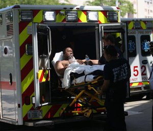 One of three injured firefighters is wheeled into Stroger Hospital on July 31, 2016, after a residential fire.