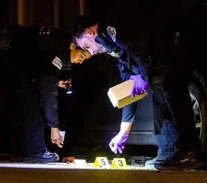 In this June 3, 2019, file photo Chicago Police officers investigate the scene where a man was shot in the Fuller Park neighborhood of Chicago. (Tyler LaRiviere/Chicago Sun-Times via AP, File)