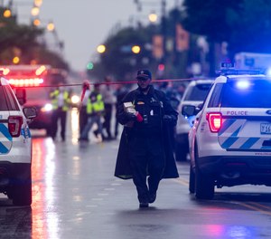 Chicago police investigate the scene of a mass shooting where more then a dozen people were shot in the Gresham neighborhood, of Chicago, Tuesday, July 21, 2020.