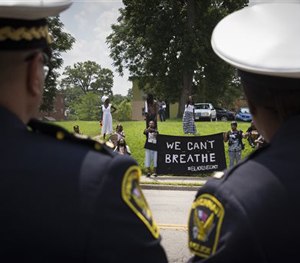 Cincinnati Police Chief Jeffrey Blackwell, left, looks at protestors, Tuesday, July 28, 2015.