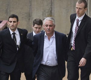 In this Dec. 9, 2015 file photo, former Suffolk County Police Chief James Burke is escorted to a vehicle by FBI personnel outside an FBI office in Melville, N.Y.