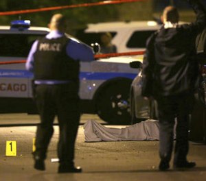 In this May 30, 2016 file photo, police work the scene where a man was fatally shot in the chest in Chicago's Washington Park neighborhood. (E. Jason Wambsgans/Chicago Tribune via AP, File)