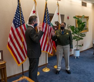 California Gov. Gavin Newsom administers the oath of office to Commissioner Amanda Ray.