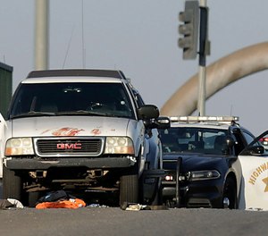 Authorities investigate the scene on the Eastridge Avenue overpass over Interstate 215, where a fatal shootout occurred, Monday, Aug. 12, 2019, in Riverside, Calif.