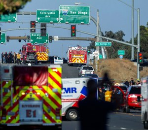 Authorities work the scene where a shootout near a freeway killed a California Highway Patrol officer and wounded two others before the gunman was fatally shot, Monday, Aug. 12, 2019, in Riverside, Calif. (Terry Pierson/The Orange County Register via AP)