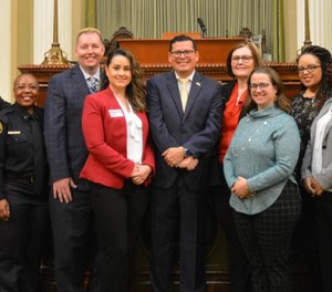 California Assembly Member Rudy Salas (center) introduced Assembly Bill 1945, which was signed by Gov. Gavin Newsom on Friday, reclassifying public safety dispatchers as first responders.