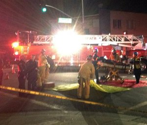 In this photo provided by Mark Milutin, firefighters carry a victim from a triage area after a driver suspected of being intoxicated hit a group of pedestrians and another car outside a church as a Christmas service ended in the Los Angeles suburb of Redondo Beach, Calif., Wednesday evening, Dec. 17, 2014. Three people were killed and several others were injured including five children, police said. Margo Bronstein, 56, was arrested after the crash on suspicion of driving under the influence and vehicular manslaughter, Redondo Beach police Lt. Shawn Freeman said. (AP Photo/Mark Milutin)