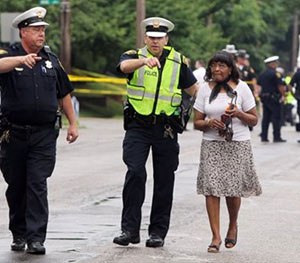 Cincinnati police lead a woman away from an area where an officer-involved shooting occurred Friday.