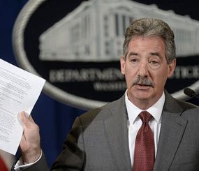 Deputy Attorney General James Cole holds up a list of guidelines during a news conference at the Justice Department in Washington, Wednesday, April 23, 2014.