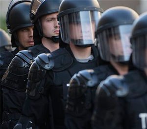 In this May 23, 2015, file photo, riot police stand in formation as a protest forms against the acquittal of Michael Brelo, a patrolman charged in the shooting deaths of two unarmed suspects in Cleveland.