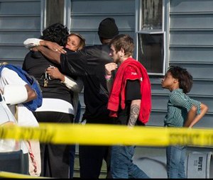 Onlookers gather outside of a house, where police say seven children and one adult have been found dead Monday, April 6, 2015, in Princess Anne, Md. Police were sent to the home Monday after being contacted by a concerned co-worker of the adult. (AP Photo/The Daily Times, Joe Lamberti)
