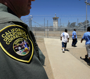 In this June 20, 2018 file photo , inmates pass a correctional officer as they leave an exercise yard at the California Medical Facility in Vacaville, Calif.