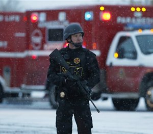 An officer stands guard near a Planned Parenthood clinic Friday, Nov. 27, 2015, in Colorado Springs, Colo.
