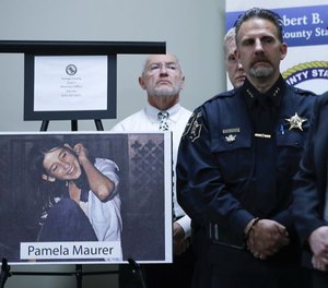 A photograph of Pamela Maurer is displayed as law enforcement officials listen to DuPage County State's Attorney Robert Berlin (not pictured) speak at a news conference regarding her 1976 slaying. (Photo/TNS)