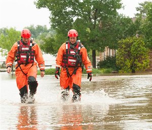 Mountain View Fire Rescue department firefighters Jamie Wood and Steve Knoll walk through a food of water after doing a welfare check of a flooded property in rural Erie, Colo. on Thursday, Sept. 12, 2013.