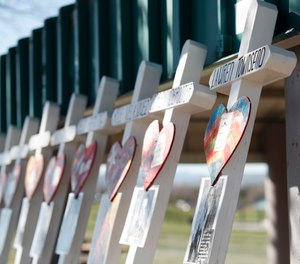 Crosses with the names of the victims of the massacre at Columbine High School nearly 20 years ago stand along a picnic site in the park before a vigil at the memorial Friday, April 19, 2019, in Littleton, Colo.