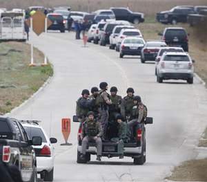 Texas Department of Public Safety officers ride in a pickup to a command post while other officers look for a gunman who shot a weather forecaster, Wednesday, Dec. 17, 2014 in Bruceville-Eddy, Texas.